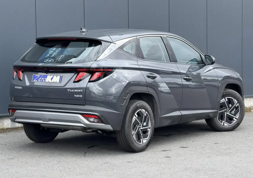 Vue 3/4 arrière droite du Hyundai Tucson 2026 Ecotronic Gray avec jantes alliage 17 pouces et antenne aileron de requin.