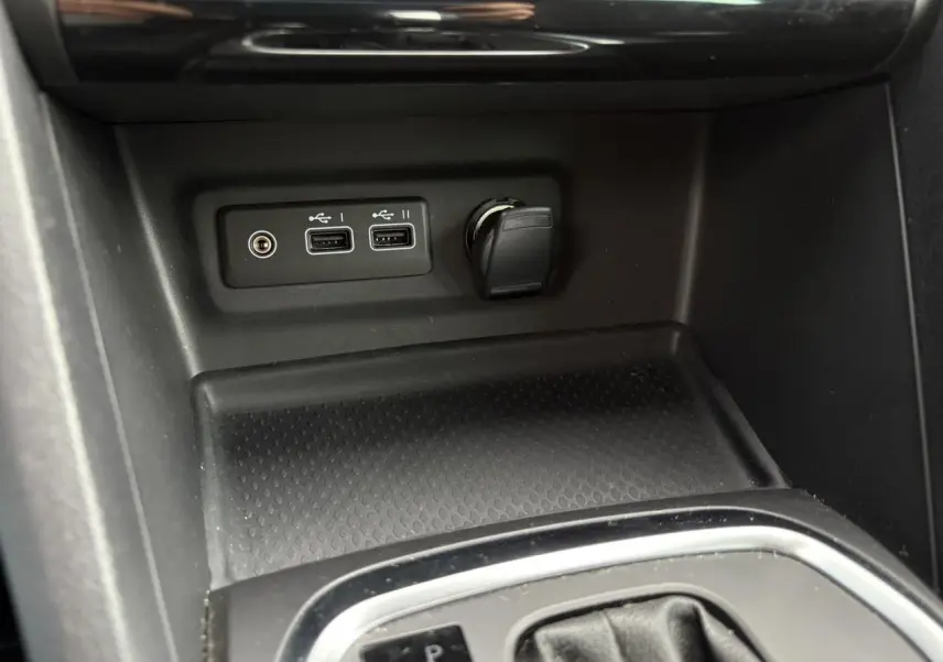 Prise USB double et allume-cigare dans la console centrale d'une Renault Mégane Break 2024 gris Highland.