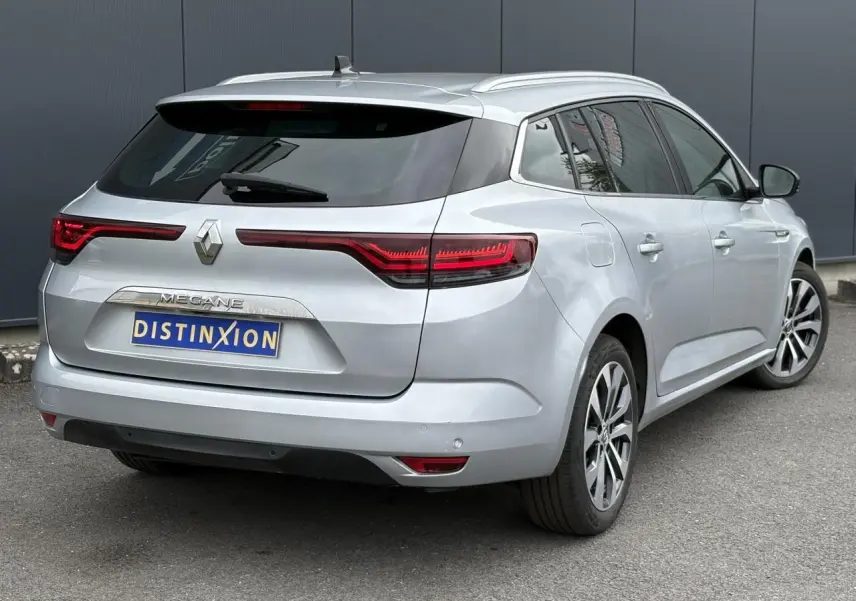 Renault Mégane Break gris Highland vue 3/4 arrière droit, feux arrière LED et jantes alliage visibles.