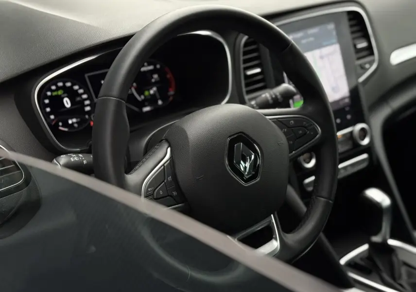 Intérieur de la Renault Mégane Break 2024, vue du volant cuir Soft Touch et écran tactile GPS EasyLink 9,3 pouces.