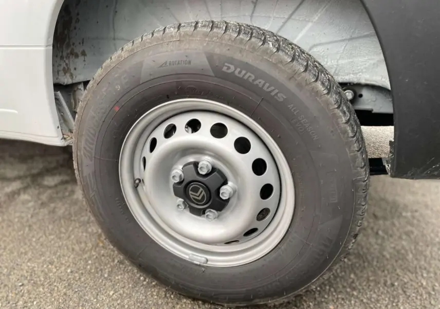 Gros plan sur la roue avant droite blanche du Citroën Jumper avec jante acier et logo Citroën au centre.