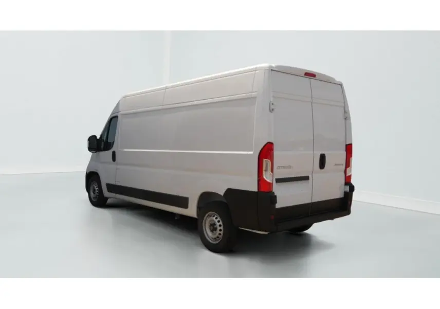 Vue 3/4 arrière droite d’un utilitaire Citroën Jumper blanc avec porte latérale coulissante et hayon arrière fermé.