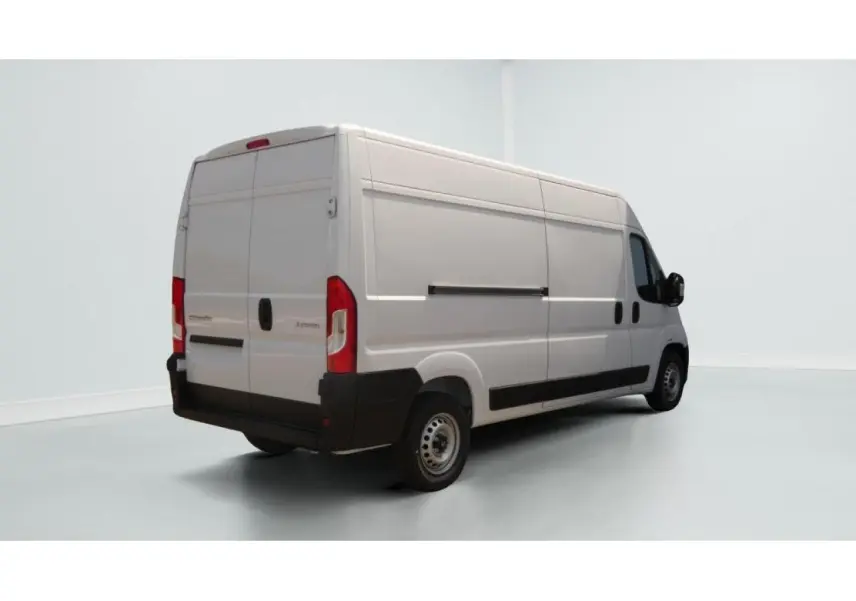 Vue 3/4 arrière droite d’un utilitaire Citroën Jumper blanc avec porte latérale coulissante et crochet d’attelage.