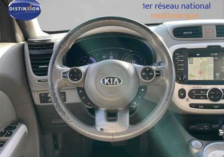 Vue intérieure centrée sur le volant gris du Kia Soul EV 2016 avec tableau de bord et écran tactile de navigation.