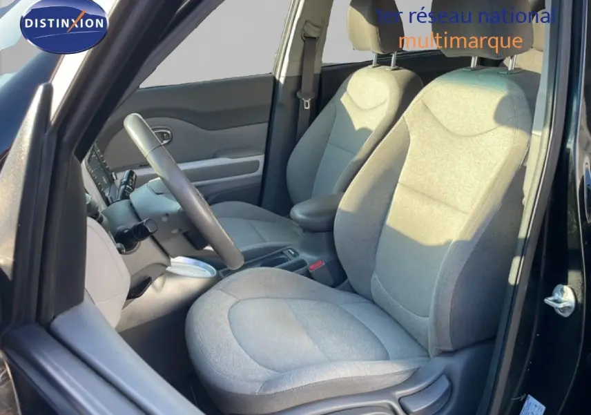 Vue intérieure côté conducteur du Kia Soul EV 2016 avec sièges tissu gris et volant multifonction.