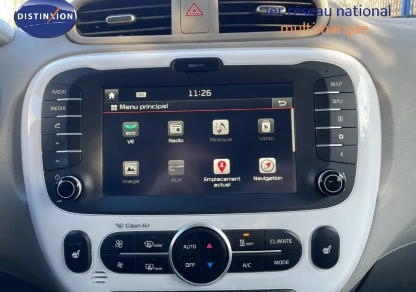Vue rapprochée de l'écran tactile central et des commandes de climatisation du Kia Soul EV 2016 noir Shadow Metal avec toit rouge.