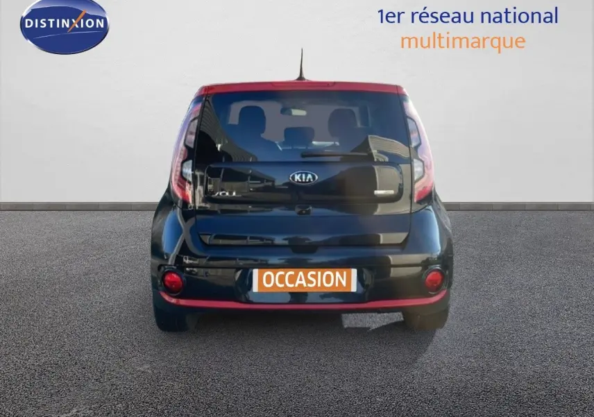 Vue arrière d'une Kia Soul EV électrique 2016 noire Shadow Metal avec toit rouge et détails rouges au bas du pare-chocs.