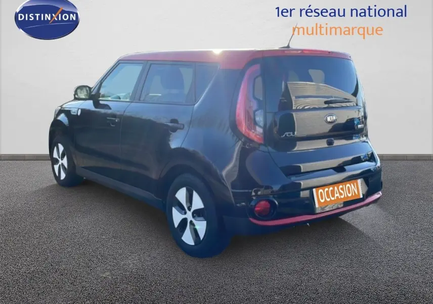 Vue 3/4 arrière droite d'une Kia Soul EV électrique noire Shadow Metal avec toit rouge et jantes blanches.