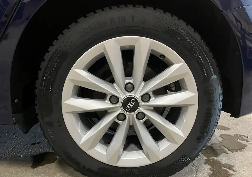 Gros plan sur la roue avant droite d’une Audi A3 Sportback bleu métallisé, avec jante alliage à 10 branches.