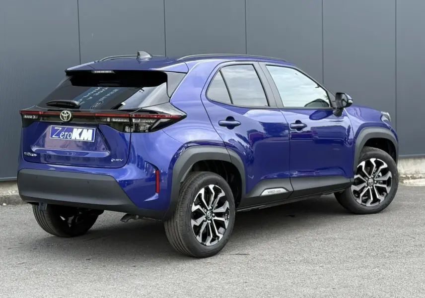 Vue 3/4 arrière droite d'une Toyota Yaris Cross bleu Genievre avec jantes alliage et toit noir contrasté.
