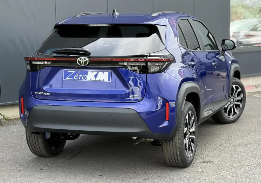 Vue 3/4 arrière droite d'une Toyota Yaris Cross 1.5 Hybrid bleu Genievre avec feux arrière LED et jantes alliage.