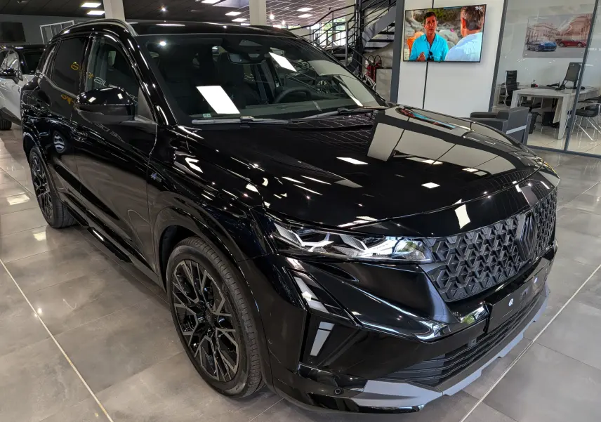Renault Austral full hybrid noir en 3/4 avant droit, avec calandre texturée et jantes noires distinctives.