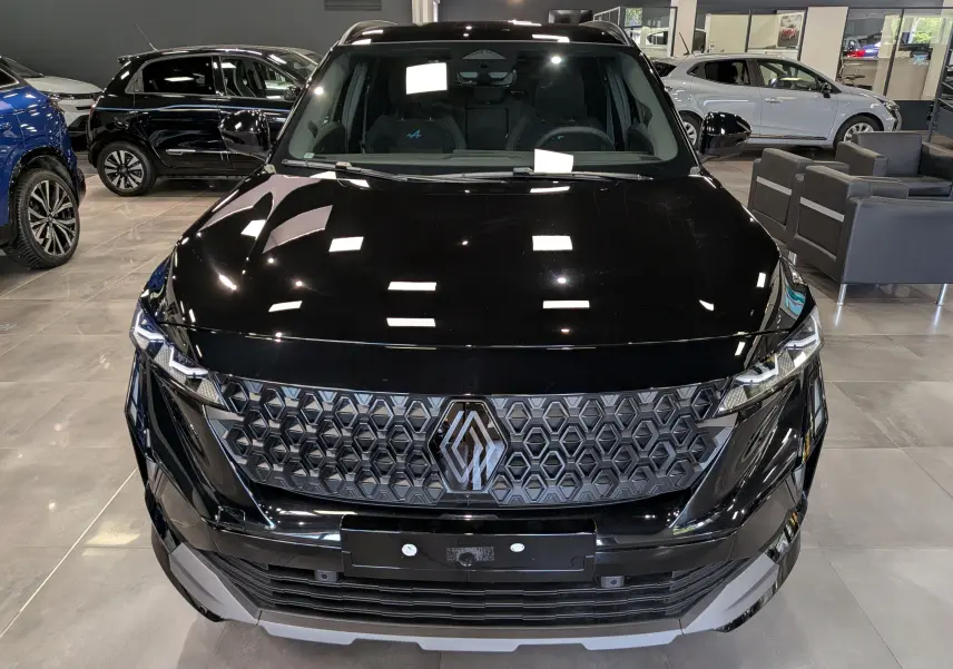 Vue avant rapprochée du Renault Austral noir full hybrid E-Tech 200 ch avec calandre hexagonale et logo Alpine visible.