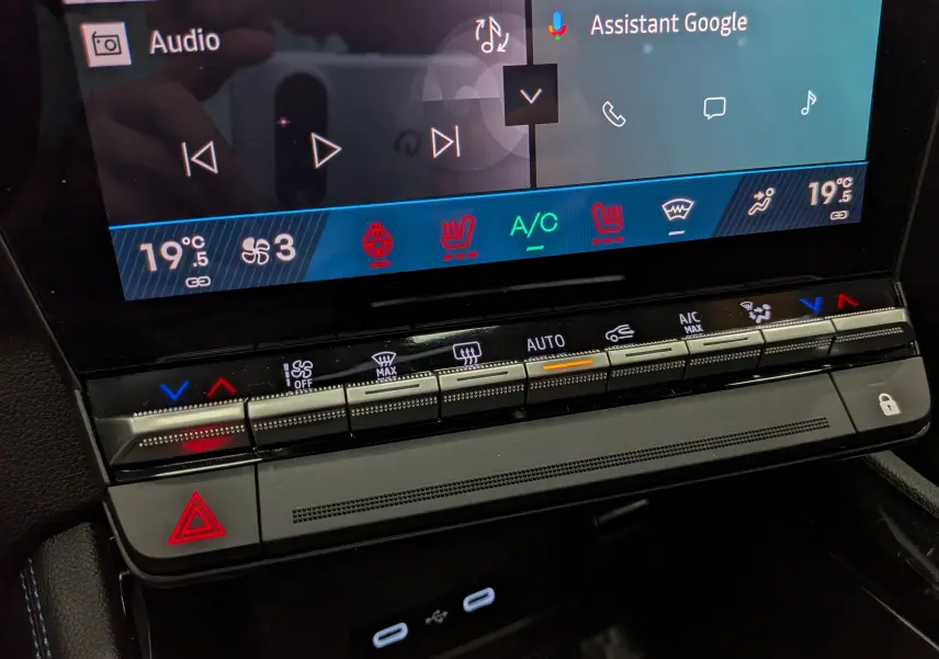 Gros plan sur l’écran tactile et les commandes de climatisation du Renault Austral noir, affichant 19,5°C et options chauffantes activées.