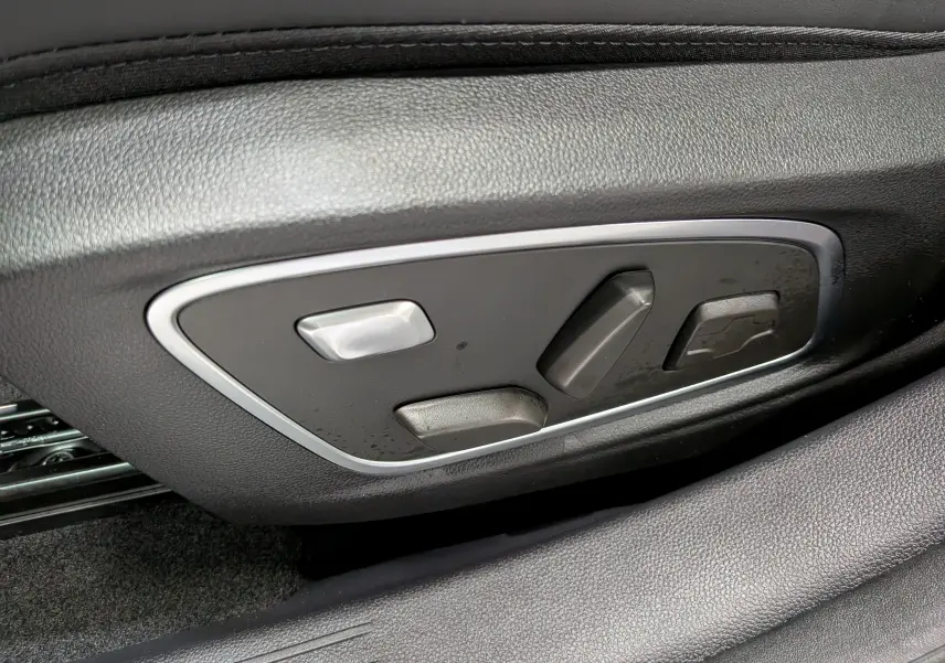 Détail des commandes de réglage électrique du siège côté gauche, sur Renault Austral noir 2026.