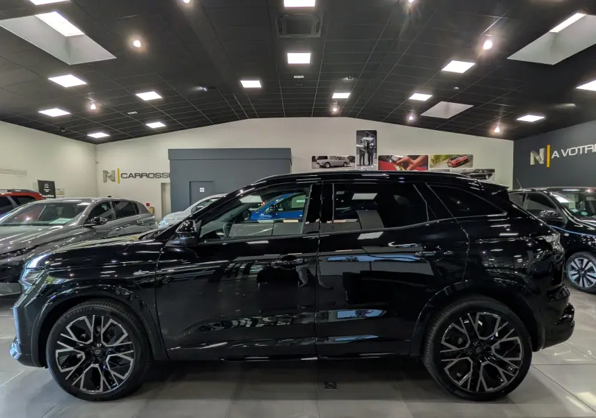 Profil côté gauche du Renault Austral noir full hybrid E-Tech 200 ch Esprit Alpine en showroom, soulignant ses jantes biton et lignes dynamiques.