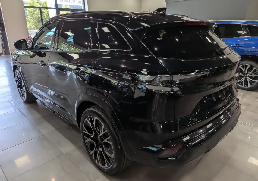 Vue 3/4 arrière droite du Renault Austral noir full hybrid E-Tech 200 ch Esprit Alpine en showroom, avec jantes noires distinctives.
