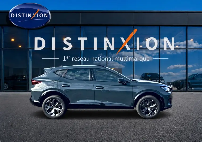 Vue latérale droite d'un CUPRA Formentor bleu fjord 2026 avec jantes 18 pouces devant une vitrine Distinxion.