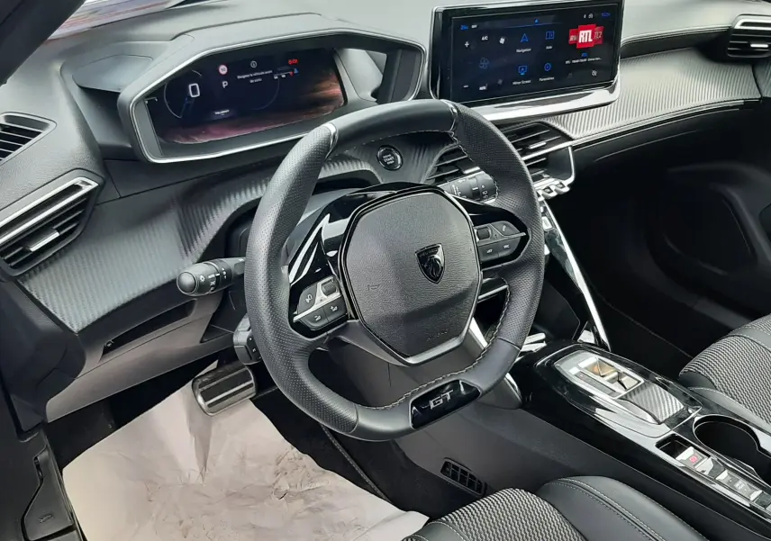 Vue arrière ouverte du coffre d'un Peugeot 2008 gris selenium, soulignant l'espace de chargement et les feux arrière.