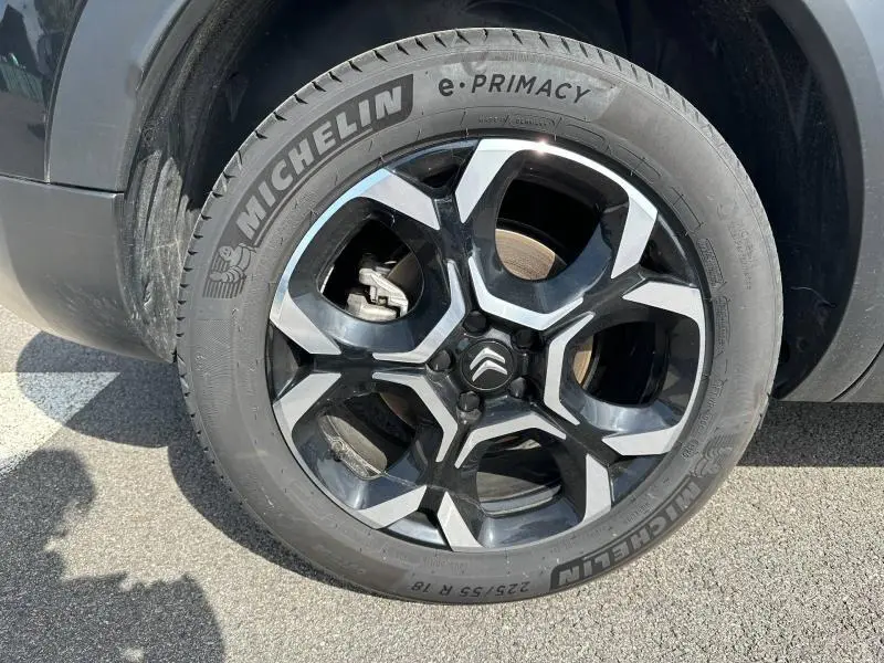 Gros plan sur la roue avant gauche noire avec jante alliage bicolore du Citroën C5 Aircross 2025 Noir Perla Nera.