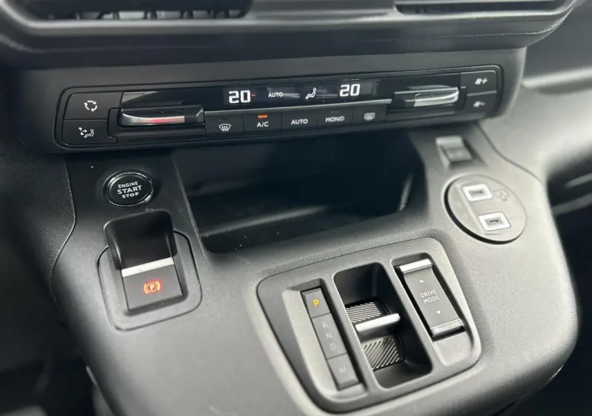 Gros plan sur la console centrale noire du Citroën Berlingo Multispace 2025 avec commandes climatisation et boîte auto.