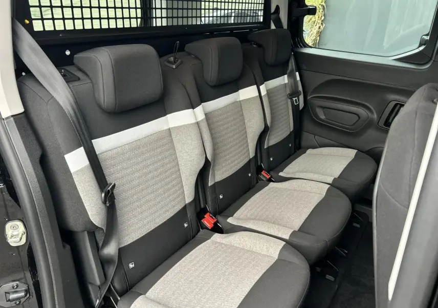 Vue latérale droite des trois sièges arrière indépendants gris et noirs du Citroën Berlingo Multispace 2025, avec ceinture et porte latérale ouverte.