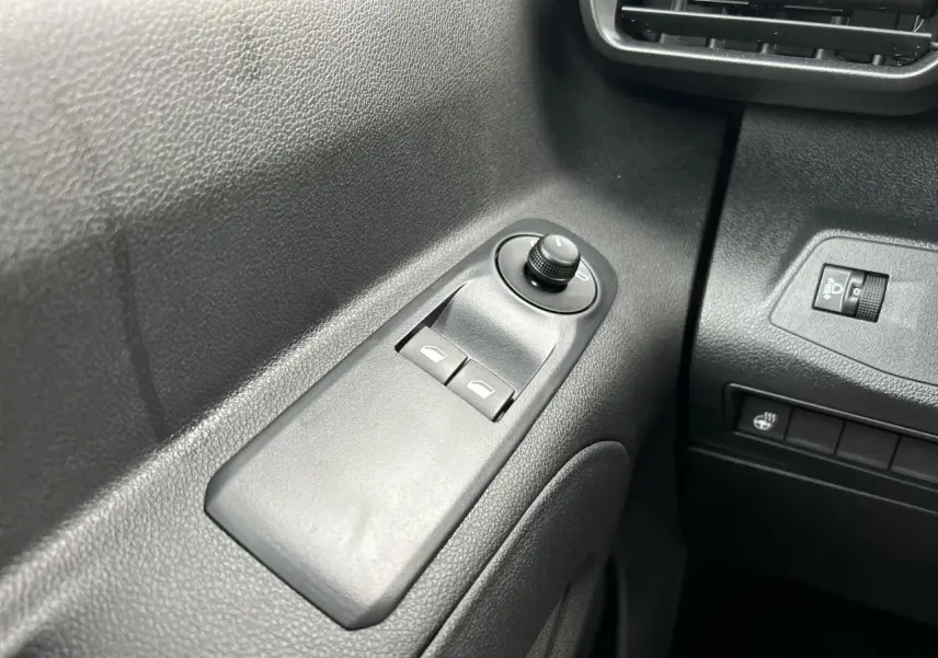Gros plan sur les commandes de lève-vitres et réglage des rétroviseurs côté gauche du Citroën Berlingo Multispace noir Perla.