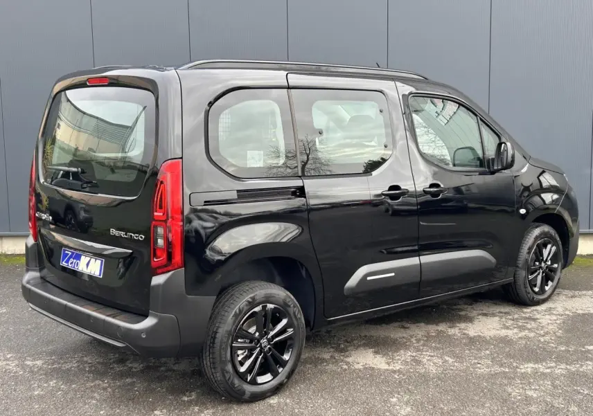 Vue 3/4 arrière droite du Citroën Berlingo Multispace noir Perla avec jantes alliage noires et barres de toit.