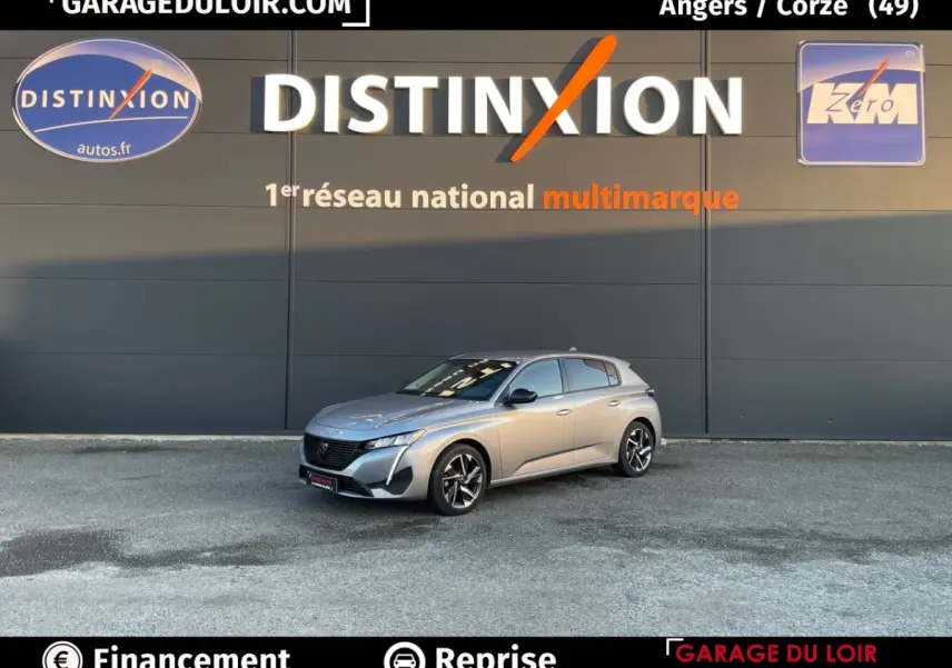 Peugeot 308 gris foncé vue en 3/4 avant droit devant un mur avec logo Distinxion.