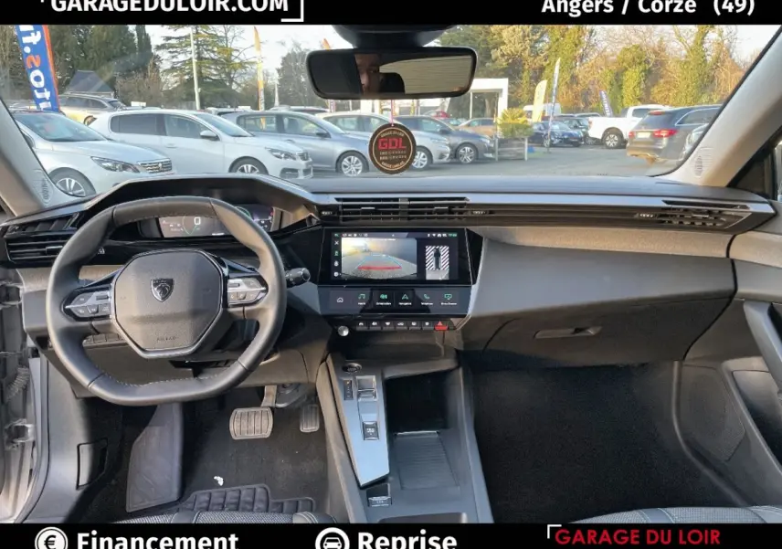 Vue intérieure de face du poste de conduite de la Peugeot 308 1.5 BlueHDi 130 Auto8 Allure gris foncé, avec écran tactile central allumé.
