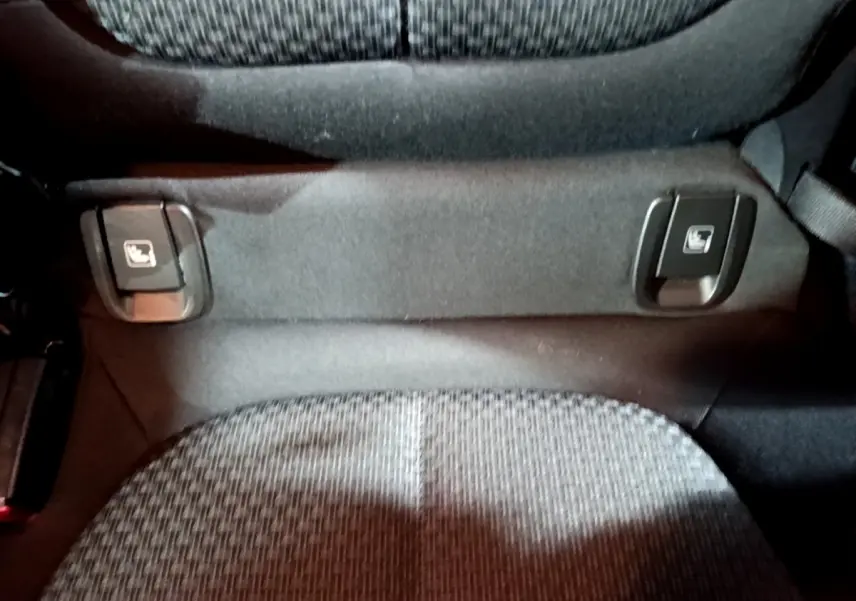 Détail des commandes Isofix sur la banquette arrière en tissu gris du BMW X2 sDrive18i Lounge noir 2023.