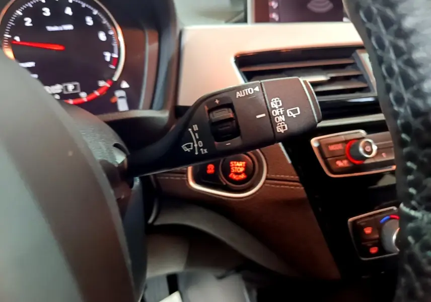 Gros plan sur la commande d’essuie-glace et le bouton start/stop dans l’habitacle noir du BMW X2 2023.