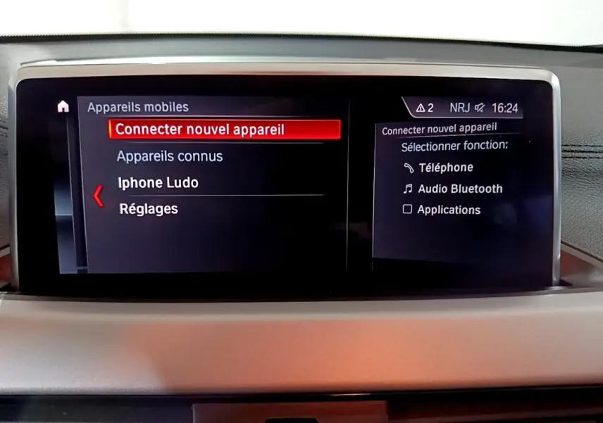 Écran central du tableau de bord de la BMW X2 sDrive18i 2023 affichant la connexion Bluetooth en cours.