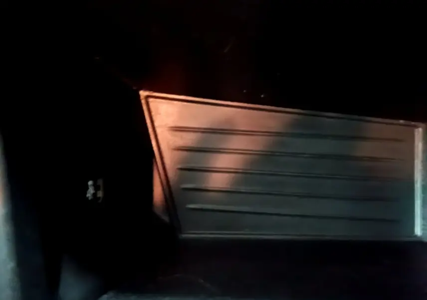 Vue intérieure du coffre noir de la BMW X2 sDrive18i Lounge DKG7 2023, avec revêtement et tablette visible.