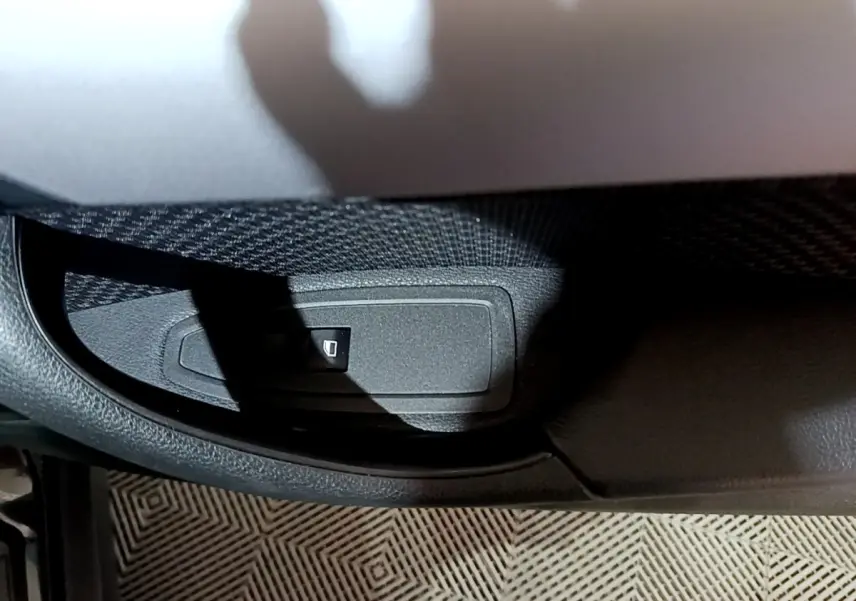 Détail du bouton de verrouillage des vitres sur la porte côté conducteur d’un BMW X2 noir 2023.