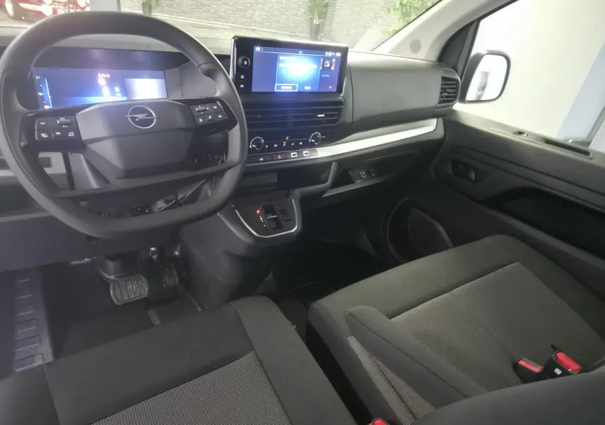 Vue intérieure avant droite de l’Opel Vivaro 2025, tableau de bord avec écran tactile 10’’ et volant multifonction noir.