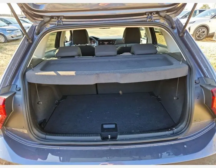 Coffre ouvert vu de l'arrière d'une Volkswagen Polo gris Ascot 2024, montrant l'espace de chargement et l'intérieur des sièges.