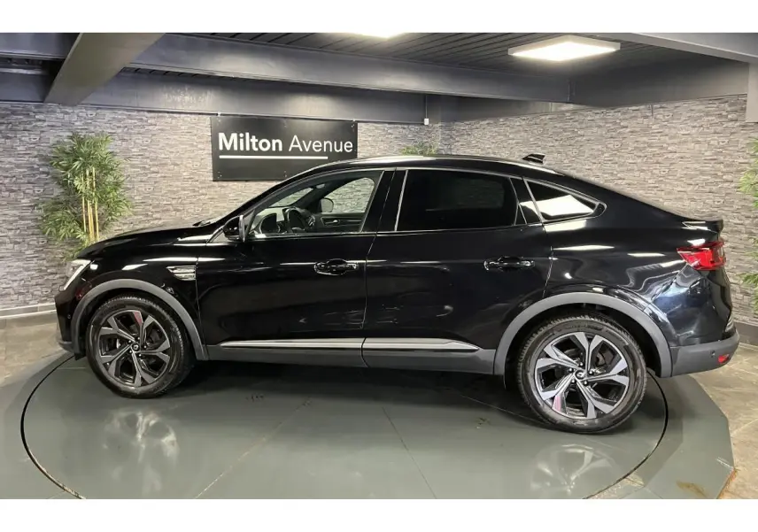 Profil côté gauche d'un Renault Arkana noir métallisé 2023 R.S. Line avec jantes alliage et toit noir.