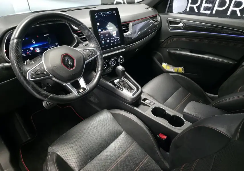 Intérieur noir du Renault Arkana R.S. Line 2023, vue côté conducteur, volant sport, écran tactile vertical et sellerie cuir/suédine.