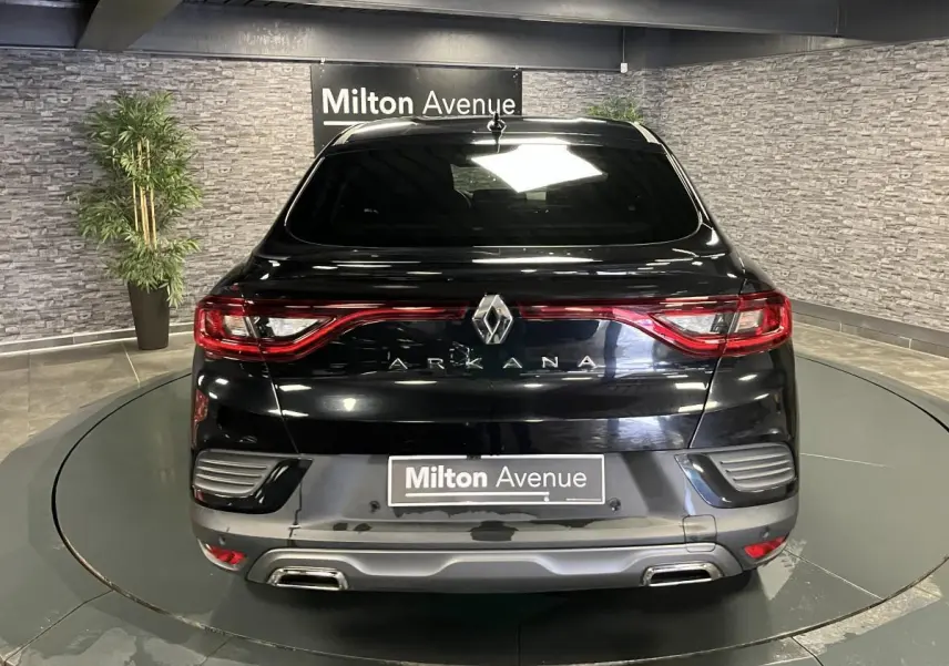 Vue arrière d’un Renault Arkana noir brillant avec feux LED en forme de C et double sortie d’échappement intégrée.