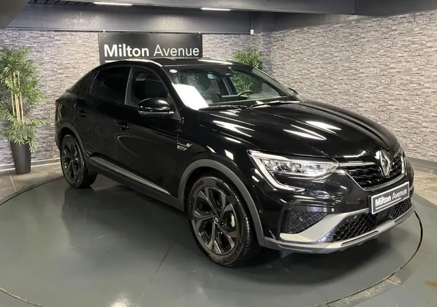 Renault Arkana R.S. Line noir métal en 3/4 avant droit, avec jantes noires et détails gris métallisé sport.