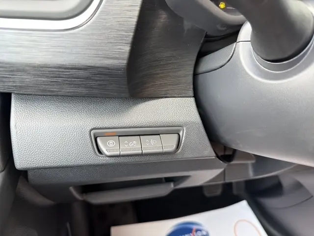 Gros plan sur les commandes sous le tableau de bord du Renault Trafic Fourgon gris foncé, côté conducteur.