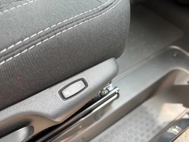 Gros plan sur le bouton de réglage du siège en tissu gris foncé dans l'habitacle du Renault Trafic Fourgon 2026.