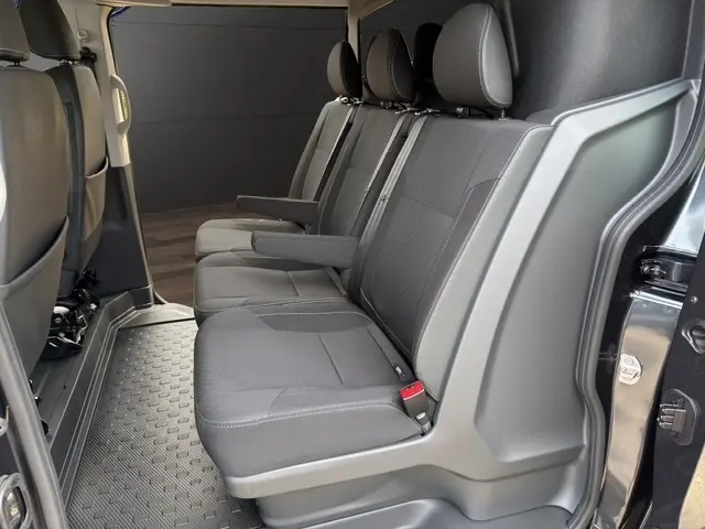 Vue intérieure côté droit du Renault Trafic Fourgon gris foncé, montrant la banquette arrière 3 places avec accoudoirs.