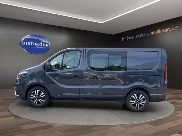 Profil côté gauche du Renault Trafic Fourgon gris foncé 2026, avec fenêtres latérales et jantes alliage visibles.