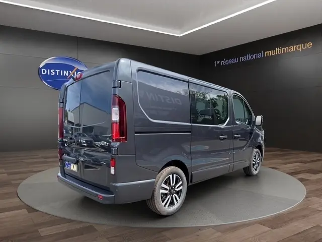 Renault Trafic Fourgon gris foncé vu en 3/4 arrière droit, avec vitres latérales teintées et jantes alliage noires.