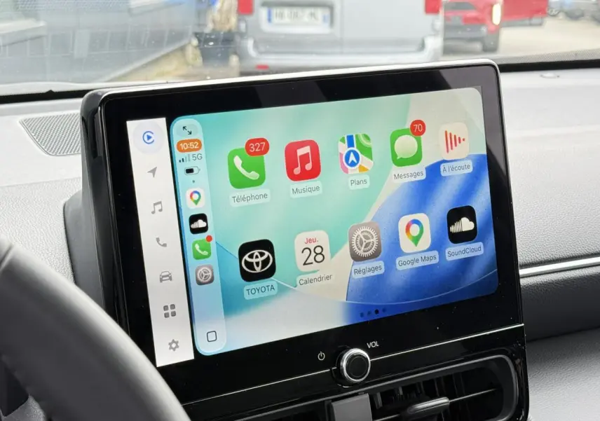 Vue intérieure centrée sur l'écran tactile 10,5 pouces du Toyota Yaris Cross 2026 avec interface Apple CarPlay visible.