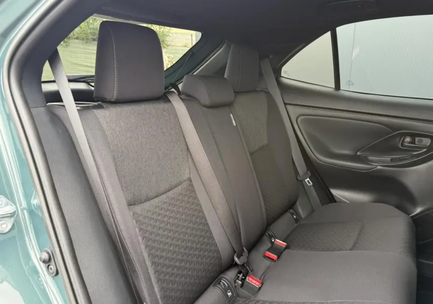 Vue intérieure du côté arrière droit de la banquette noire du Toyota Yaris Cross 1.5 Hybrid 2026 en Vert Imperial.