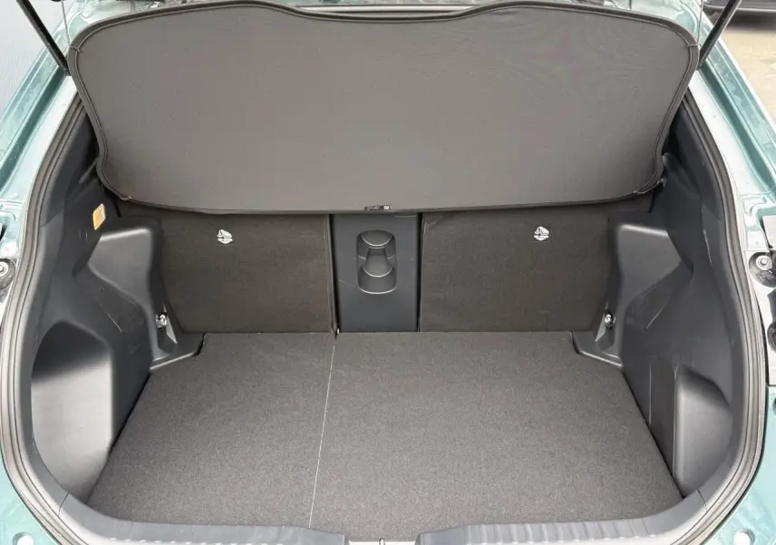Coffre ouvert de la Toyota Yaris Cross 1.5 Hybrid 2026 en Vert Impérial, montrant un plancher plat et un cache-bagages déployé.
