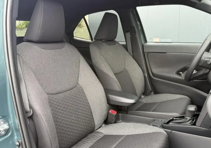 Vue intérieure côté droit des sièges avant gris foncé et clair du Toyota Yaris Cross 1.5 Hybrid 116 Design 2026.